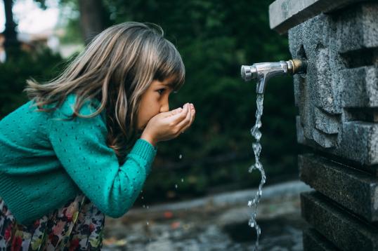 Girl drinking from a fountain