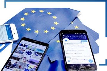 3 mobile phones on top of several EU flags