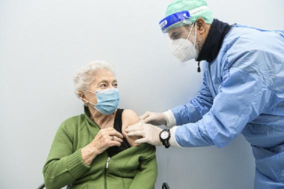 An elderly lady receives a vaccine shot
