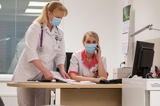 Two female doctors stand by a desk