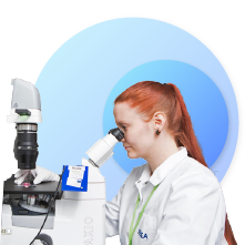 woman researcher looking into a microscope 