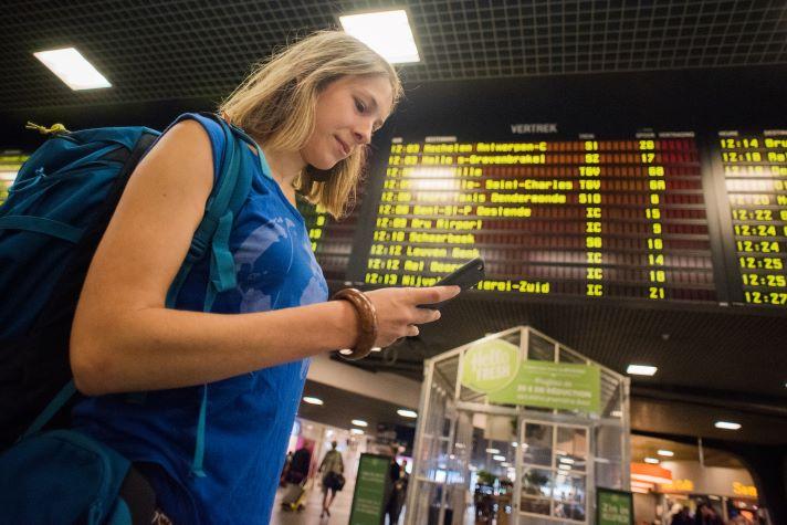 Woman looking at her smartphone in Belgian railway station