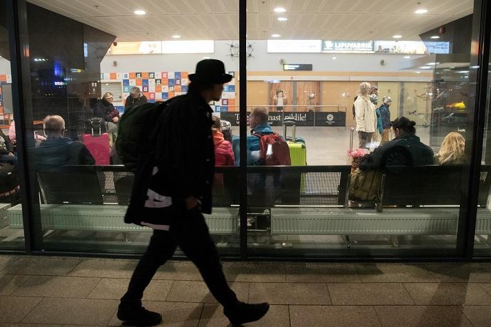 Man with backpack walking past travel centre
