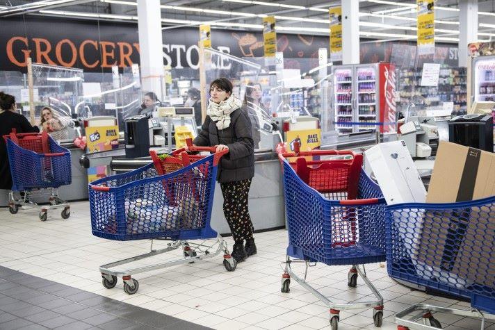 Woman pushing shopping trolley in supermarket