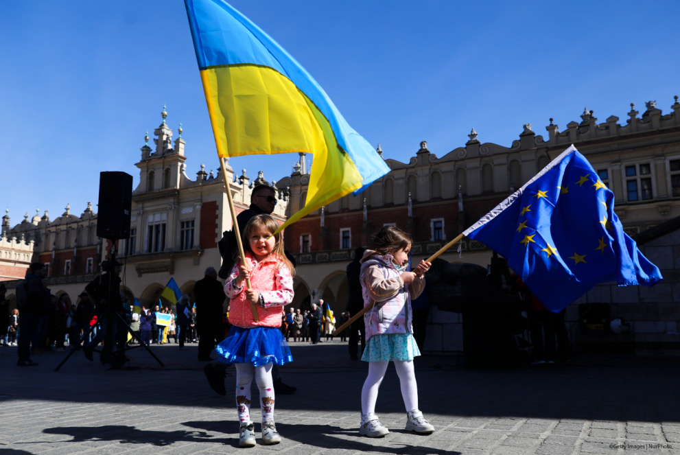 Girls hold Ukrainian and EU flags while attend a demonstration of solidarity with Ukraine