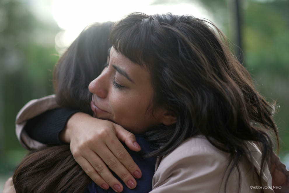 Sympathetic woman hugging friend with EMPATHY and SUPPORT