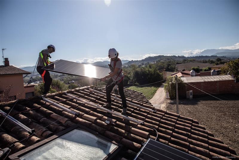 Engineers install solar panels onto the roof of a residential property in Barcelona, Spain