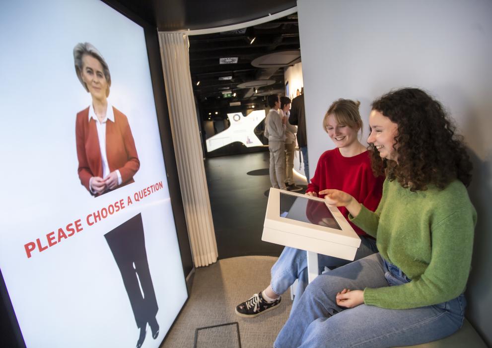 Experience Europe looking at a screen with an image of President von der Leyen