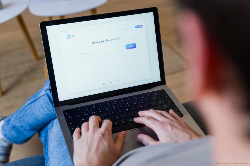 Person typing on a laptop using an AI chatbot assistant
