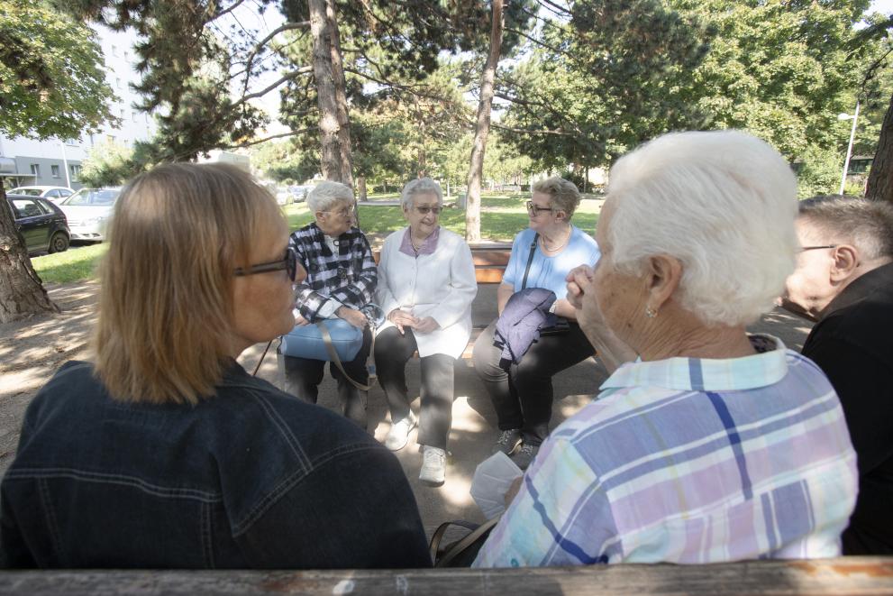 Elderly women sitting and talking to each other at a park