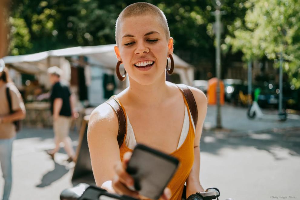 Woman using her phone to use a scooter