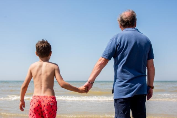 A grandfather and his grandson looking at the sea