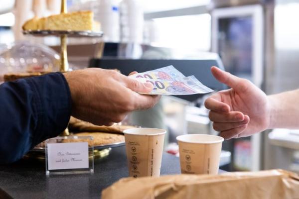 hands exchanging 40 euros over coffee counter