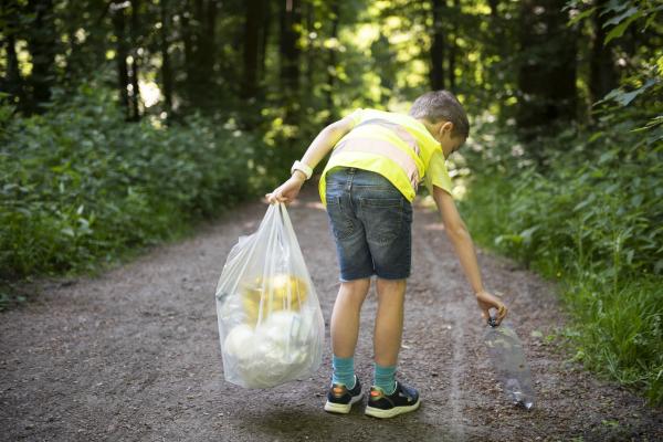 A child collecting plastic waste in a forest