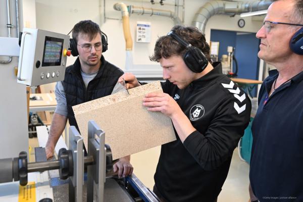 student measuring the thickness of a cut piece of wood in a highly specialised lab