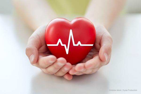 close-up-of-hand-with-cardiogram-on-red-heart 